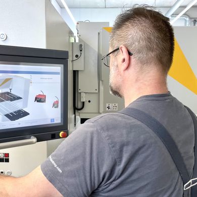 Machine operator Matthias Hirt loading a bending program on the touch control system